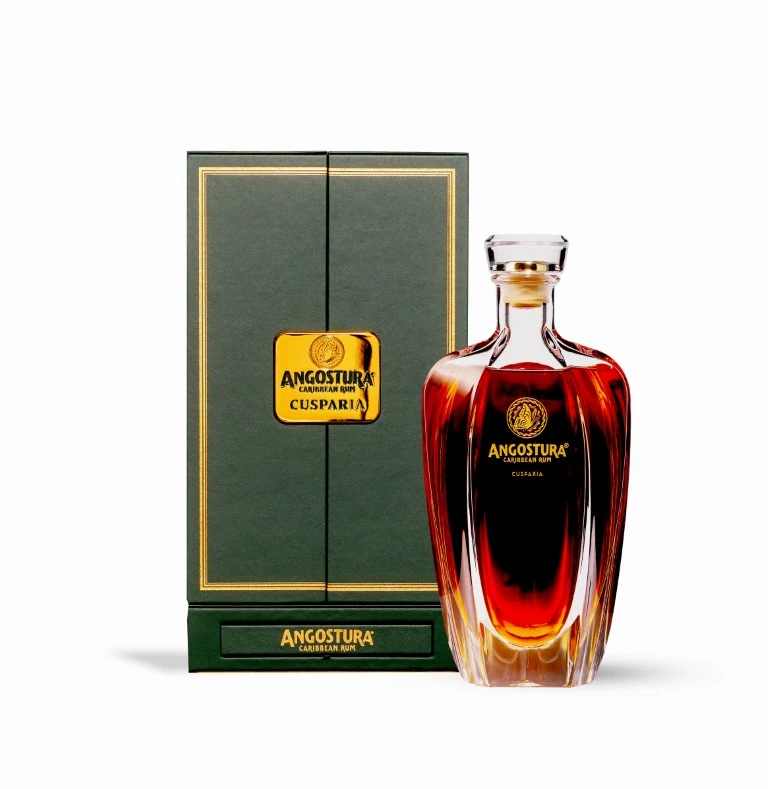 Angostura Cusparia bottle beside a closed dark green presentation case with gold detailing.