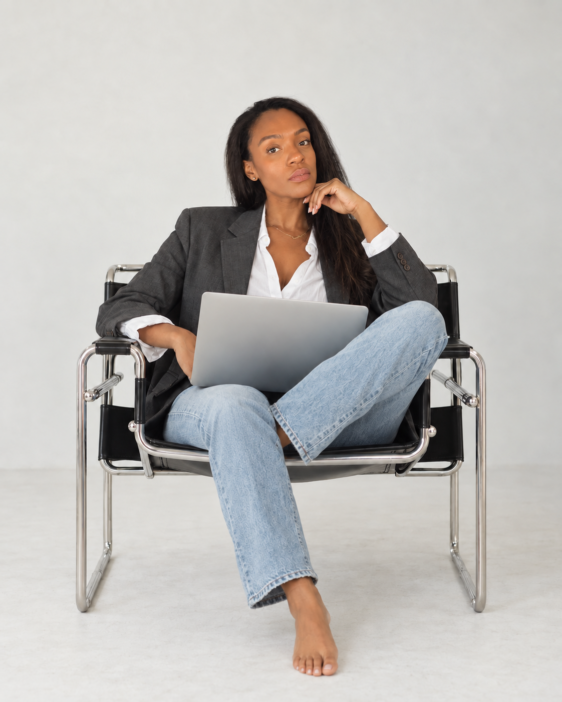 Sophie Charles-Barber seated in a leather chair with a laptop