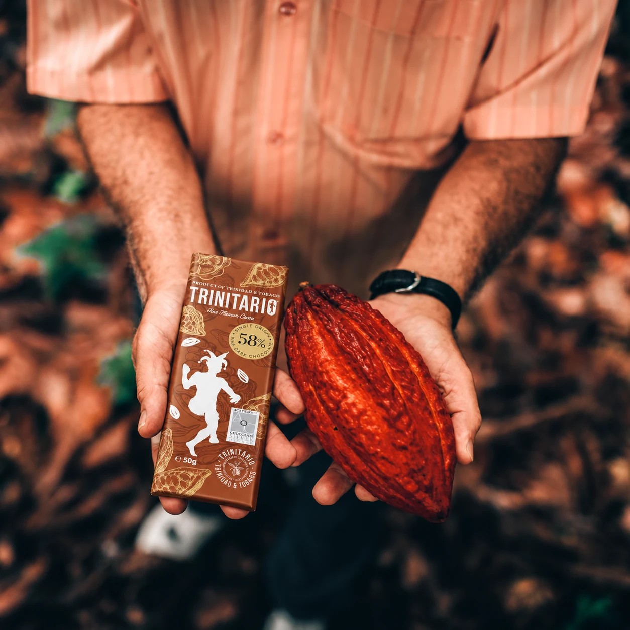 A 58% Trinitario dark chocolate bar held alongside a red cocoa pod.