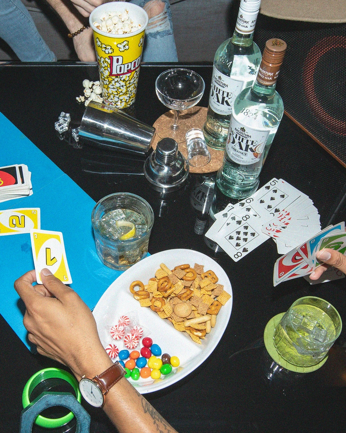 White Oak bottles and cocktails on a table during a game of cards.